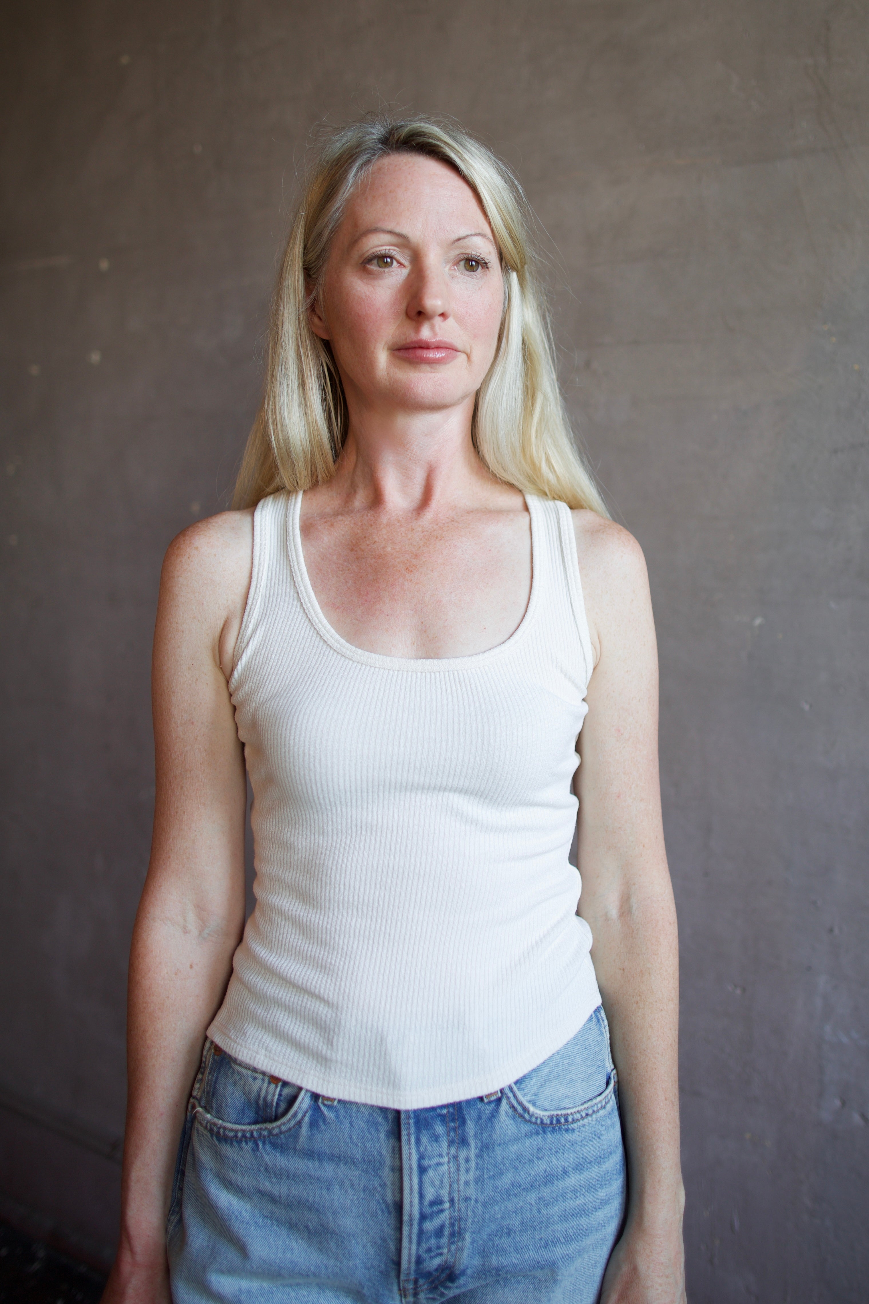 Mature model wearing luxury brand Sablyn coco scoop neck tank in premium off white colorway with textured ribbing