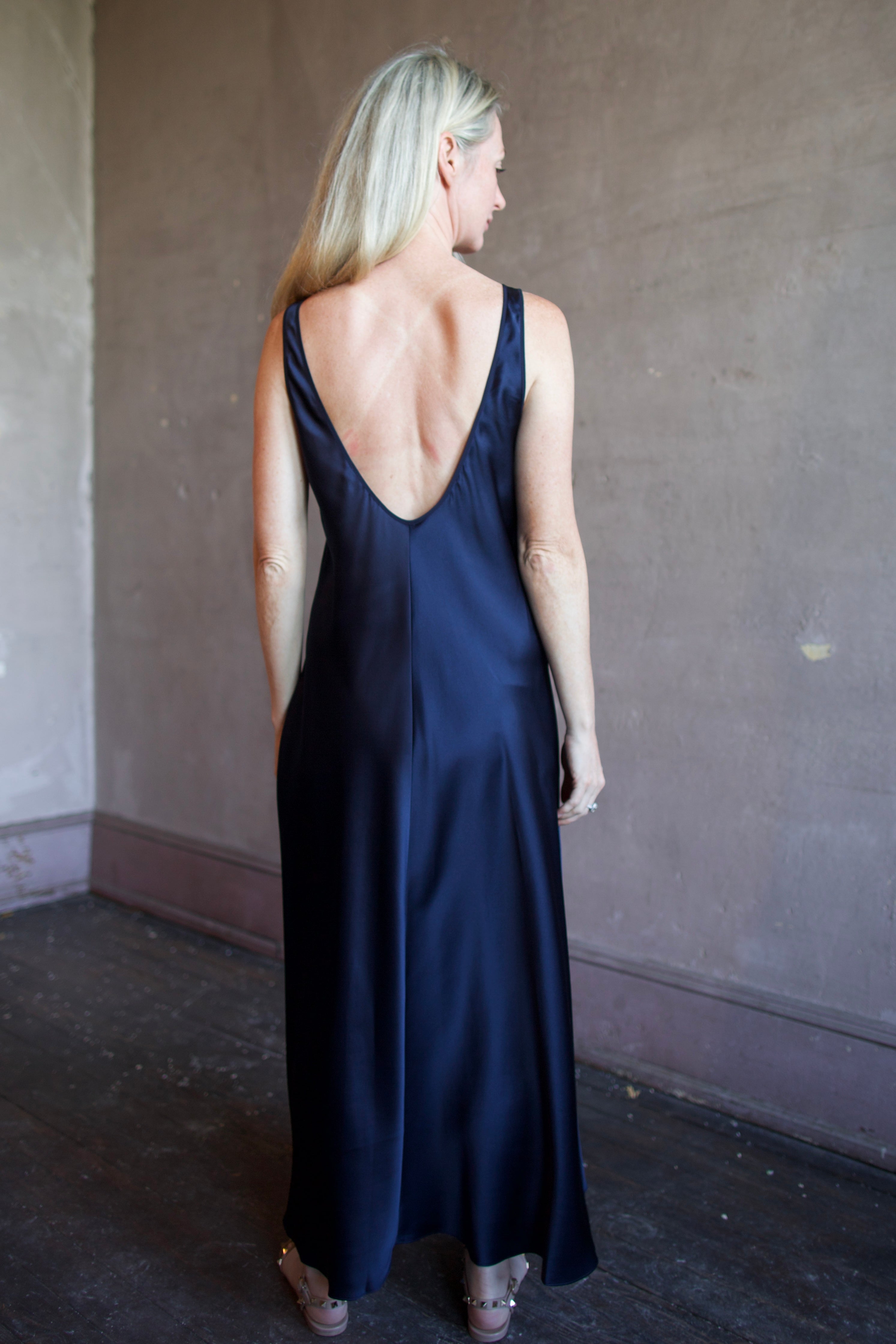 Model wearing luxury brand Sablyn silk charmeuse slip maxi dress with scoop neck and low back