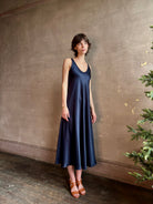 Womanl wearing luxury Sablyn navy blue silk charmeuse sleeveless slip maxi dress with scoop neck and low back 