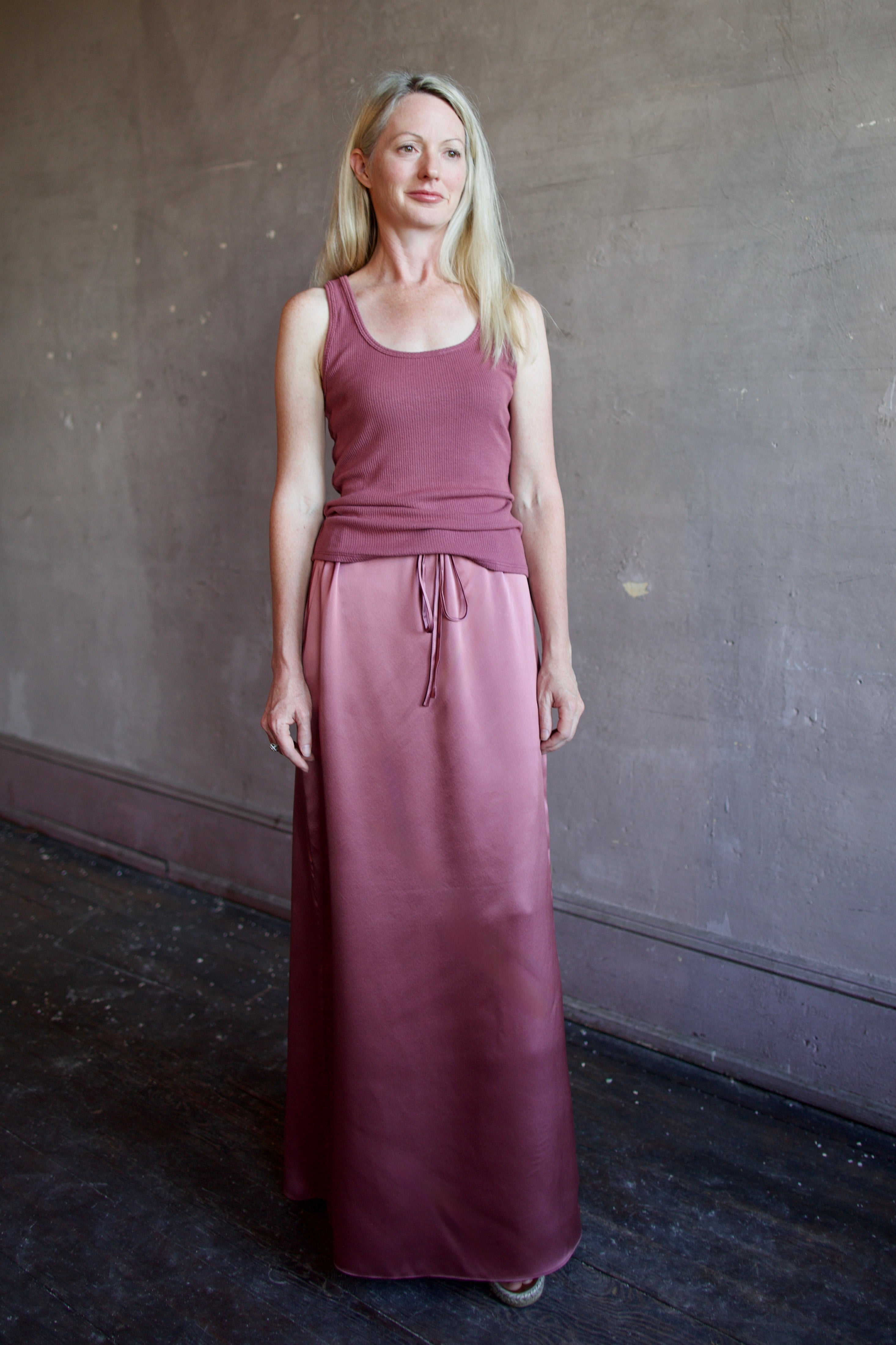 Model wearing luxury brand Sablyn Sol Drawsting waist maxi skirt in premium silk charmeuse fabric and rich mauve colorway