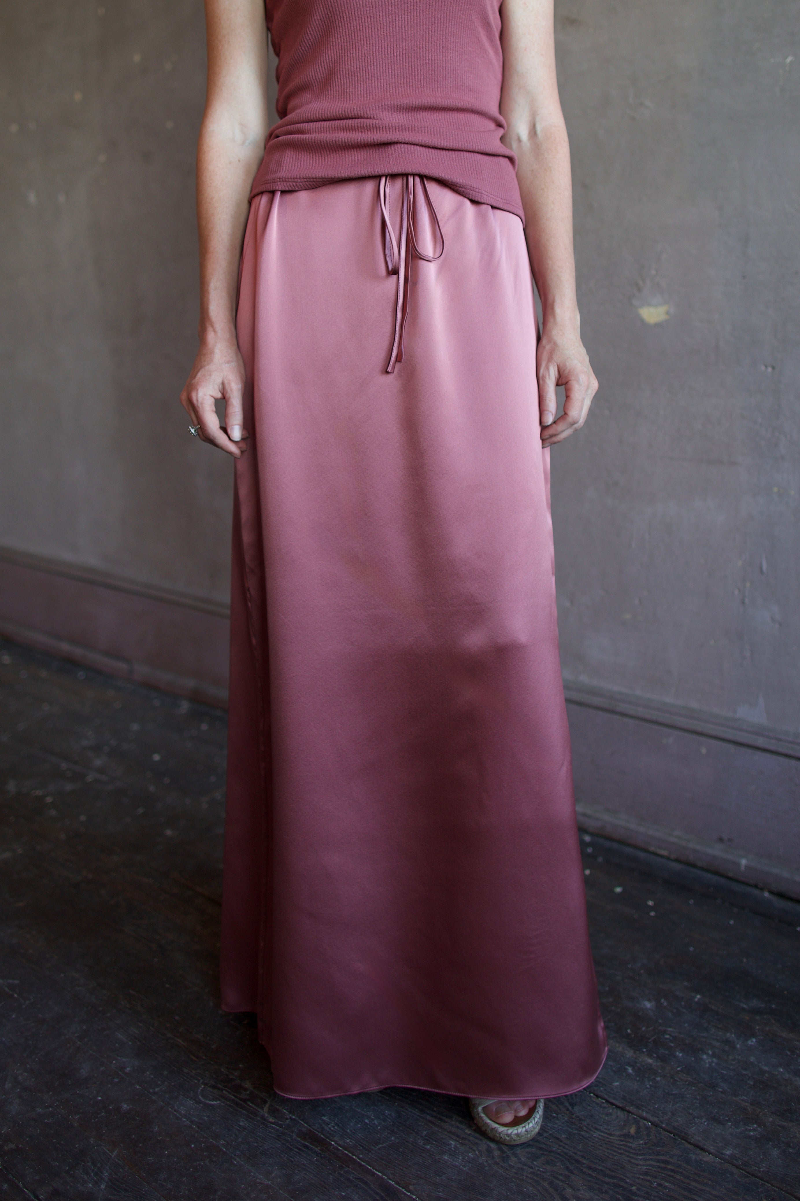 Model wearing luxury brand Sablyn Sol Drawsting waist maxi skirt in premium silk charmeuse fabric and rich mauve colorway