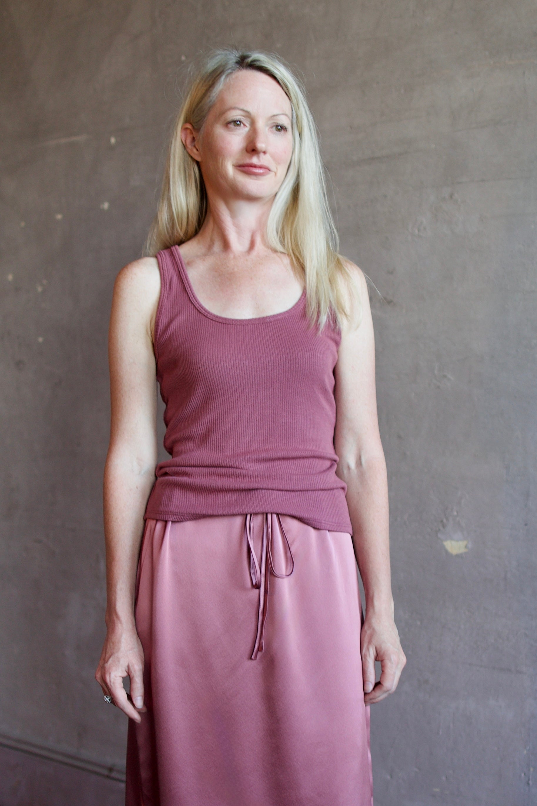 Model wearing luxury brand Sablyn layering coco scoop neck tank top in rich mauve colorway with premium ribbed texture fabric