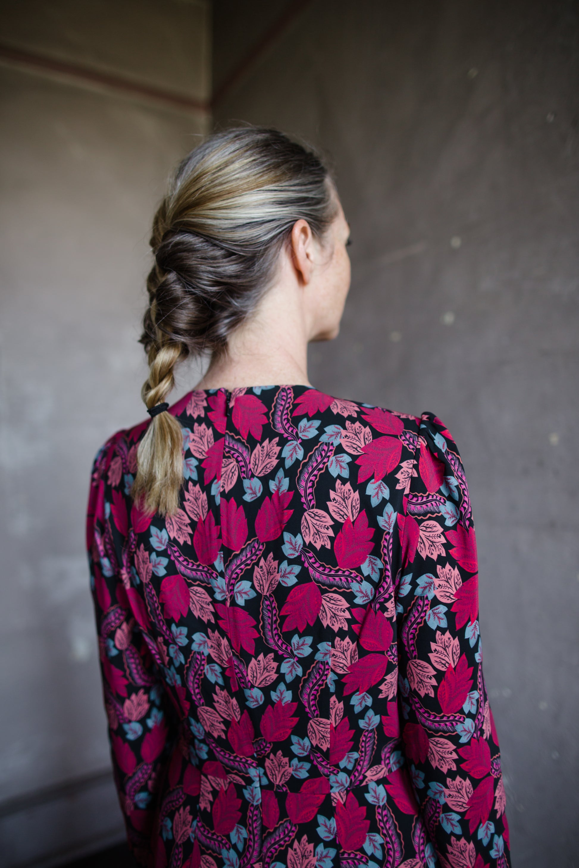 Image featuring a woman wearing the Jinx-C silk dress by Saloni with a crew neckline, long sleeves, and velvet trim cutouts down the front in a pink floral.