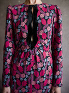 Image featuring a woman wearing the Jinx-C silk dress by Saloni with a crew neckline, long sleeves, and velvet trim cutouts down the front in a pink floral.