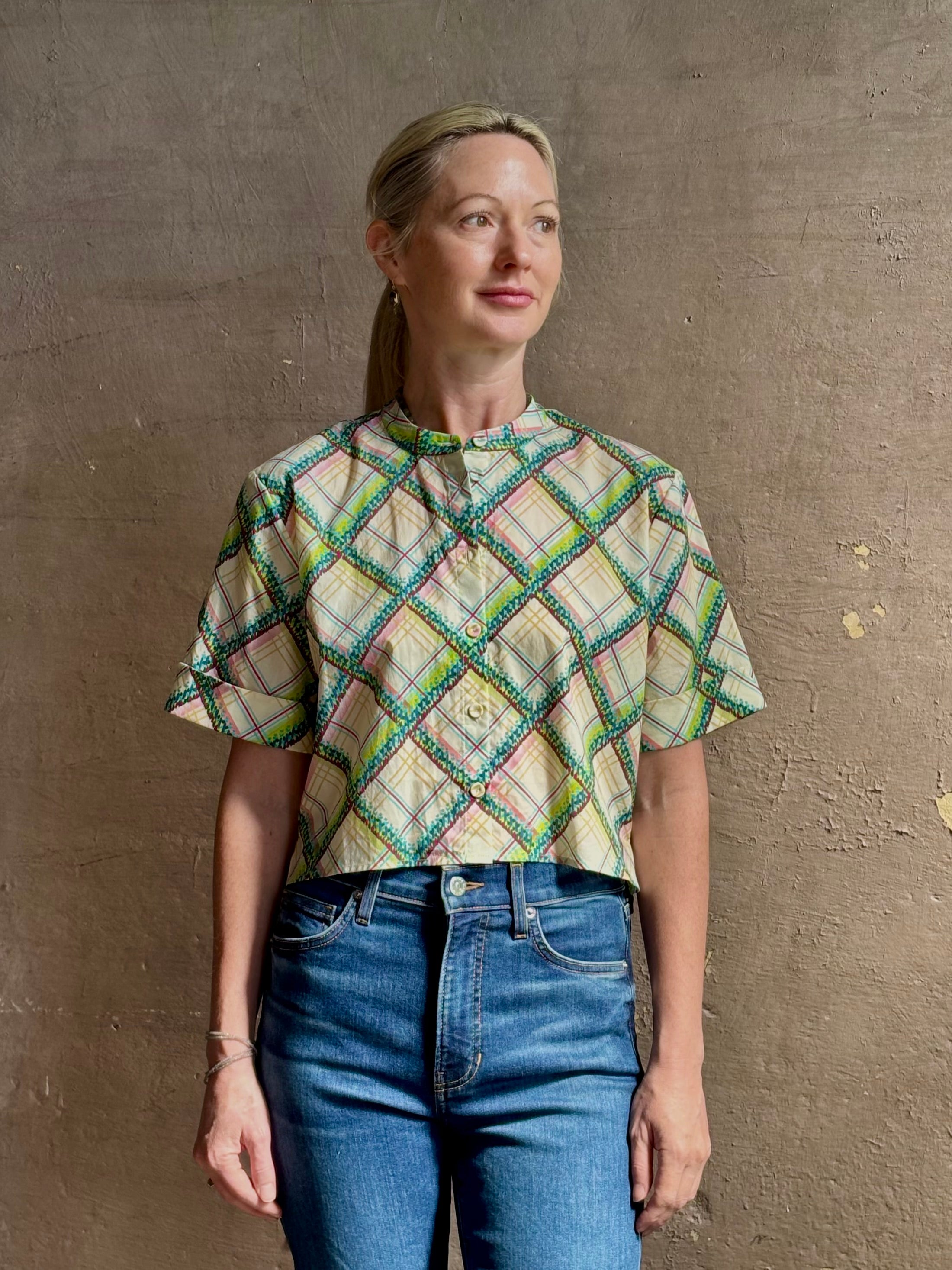 Mature woman wearing the Saloni Jude-B short sleeve plaid button up crop top crafted in cotton with happy diagonal green plaid expertly aligned pattern