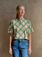 Mature woman wearing the Saloni Jude-B short sleeve plaid button up crop top crafted in cotton with happy diagonal green plaid expertly aligned pattern