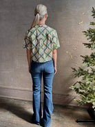 Mature woman wearing the Saloni Jude-B short sleeve plaid button up crop top crafted in cotton with happy diagonal green plaid expertly aligned pattern