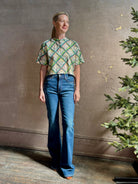 Mature woman wearing the Saloni Jude-B short sleeve plaid button up crop top crafted in cotton with happy diagonal green plaid expertly aligned pattern