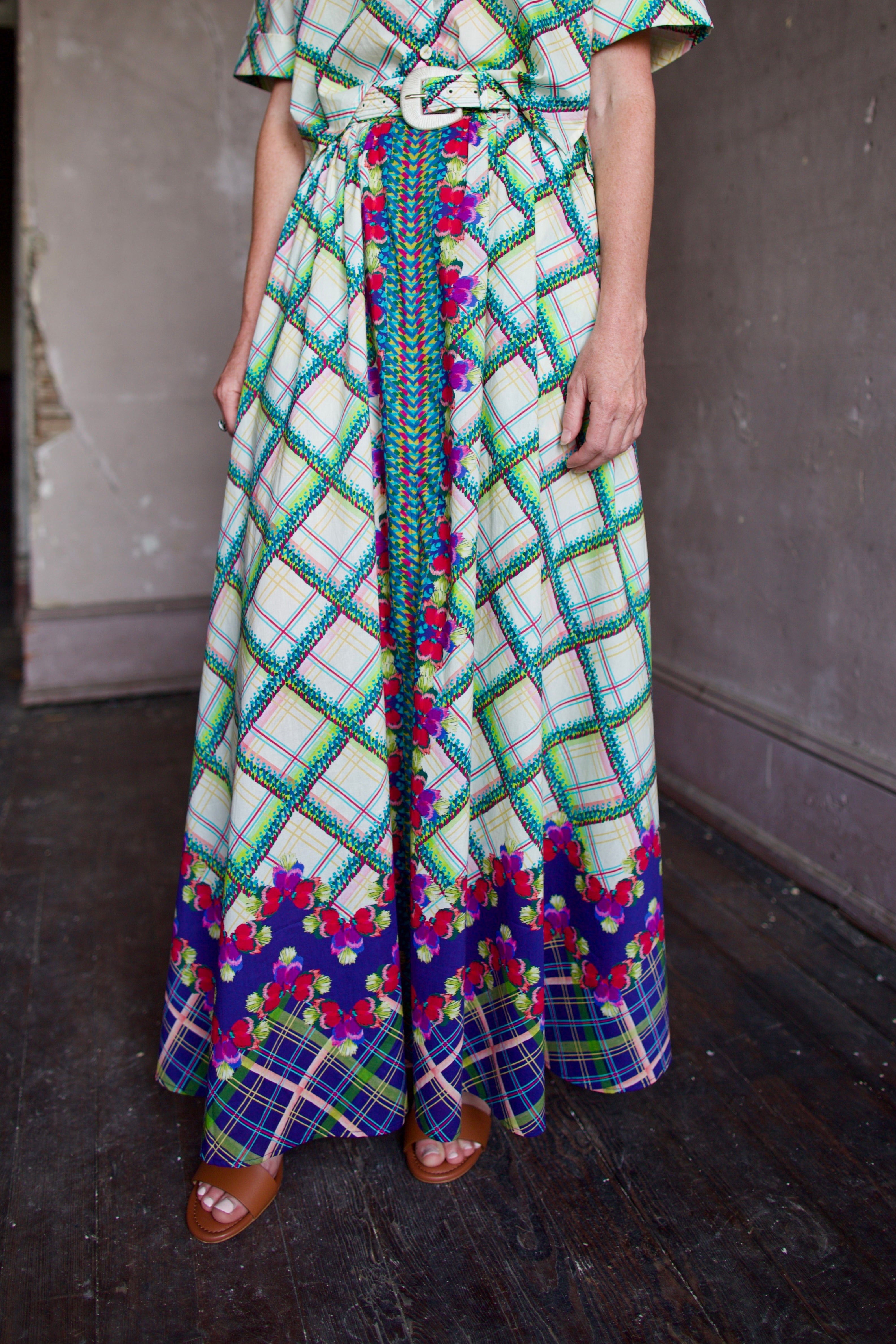 Model wearing Saloni Judi maxi plaid skirt, matching belt, and trimmed in pansies down front and around skirt bottom