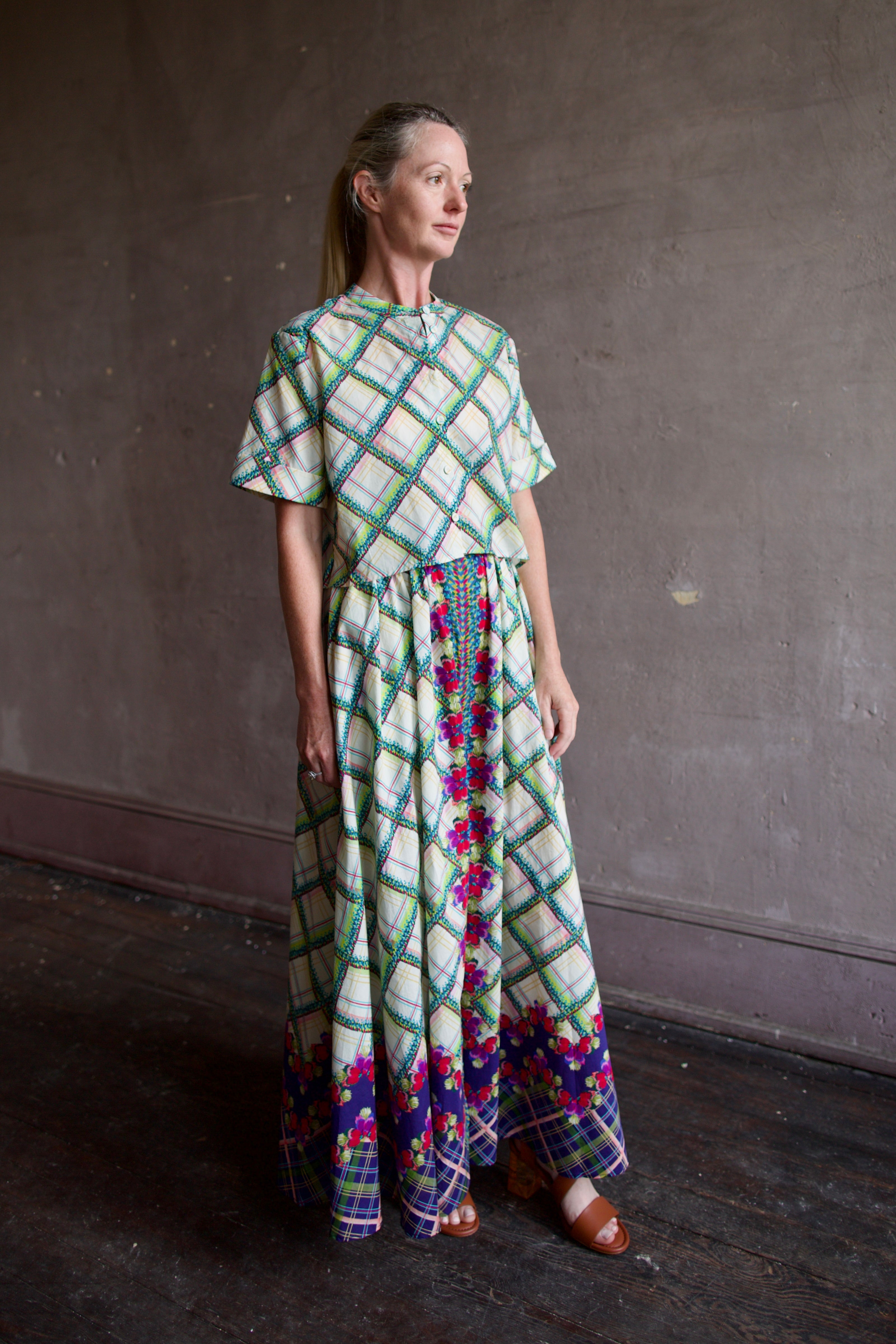 Model in Saloni Judi plaid maxi skirt with matching belt and trimmed in pansies worn with matching Jude top