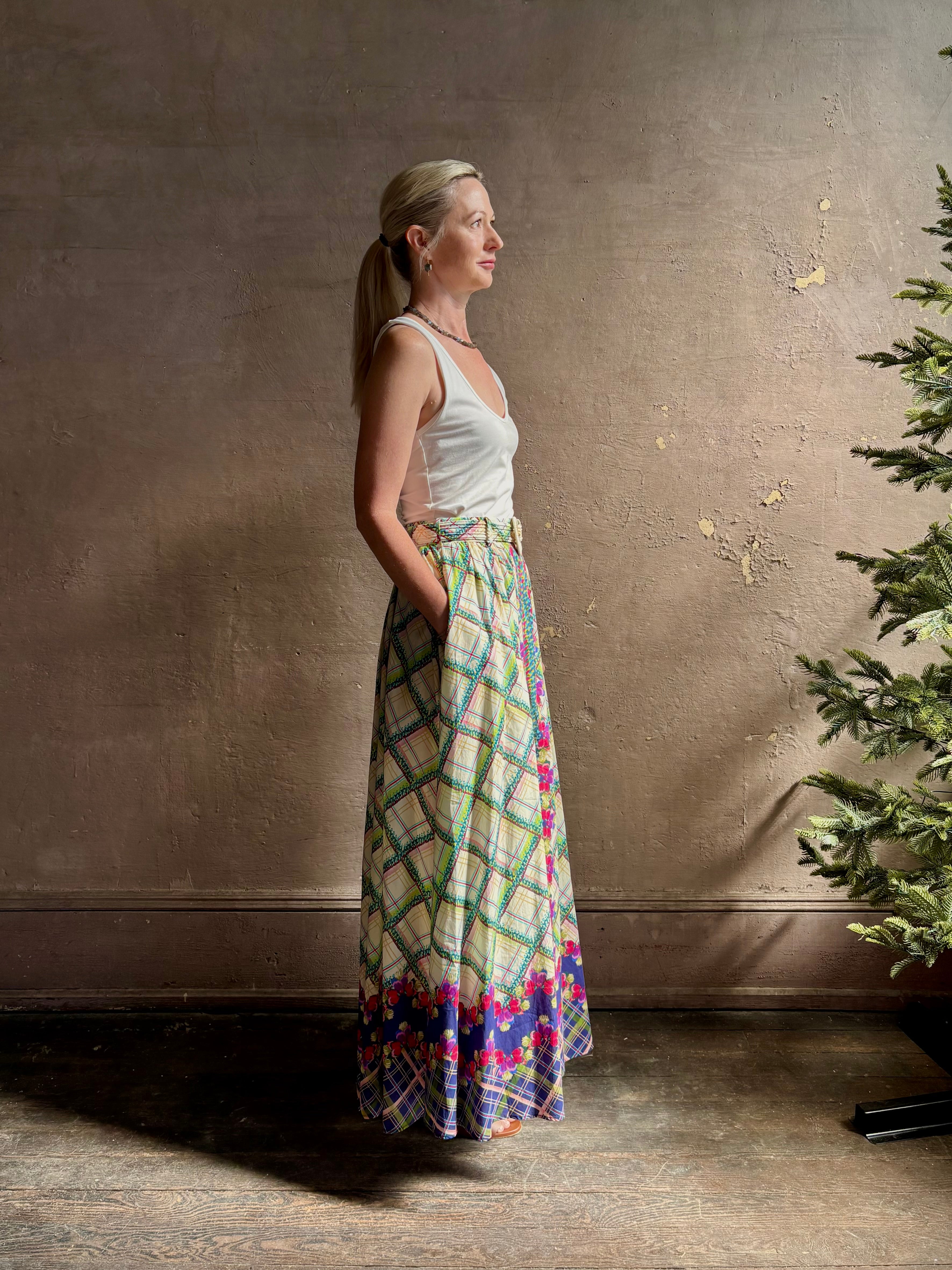 Mature woman reviewing Saloni Judi maxi plaid skirt with matching belt. This cotton A-line skirt is trimmed in pansies down front and bottom with front opening for additional ventilation