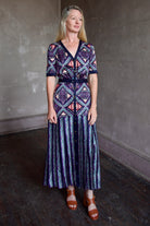 Model wearing timeless Saloni Lea drop waist shirt dress in ikat compass print and pleated 