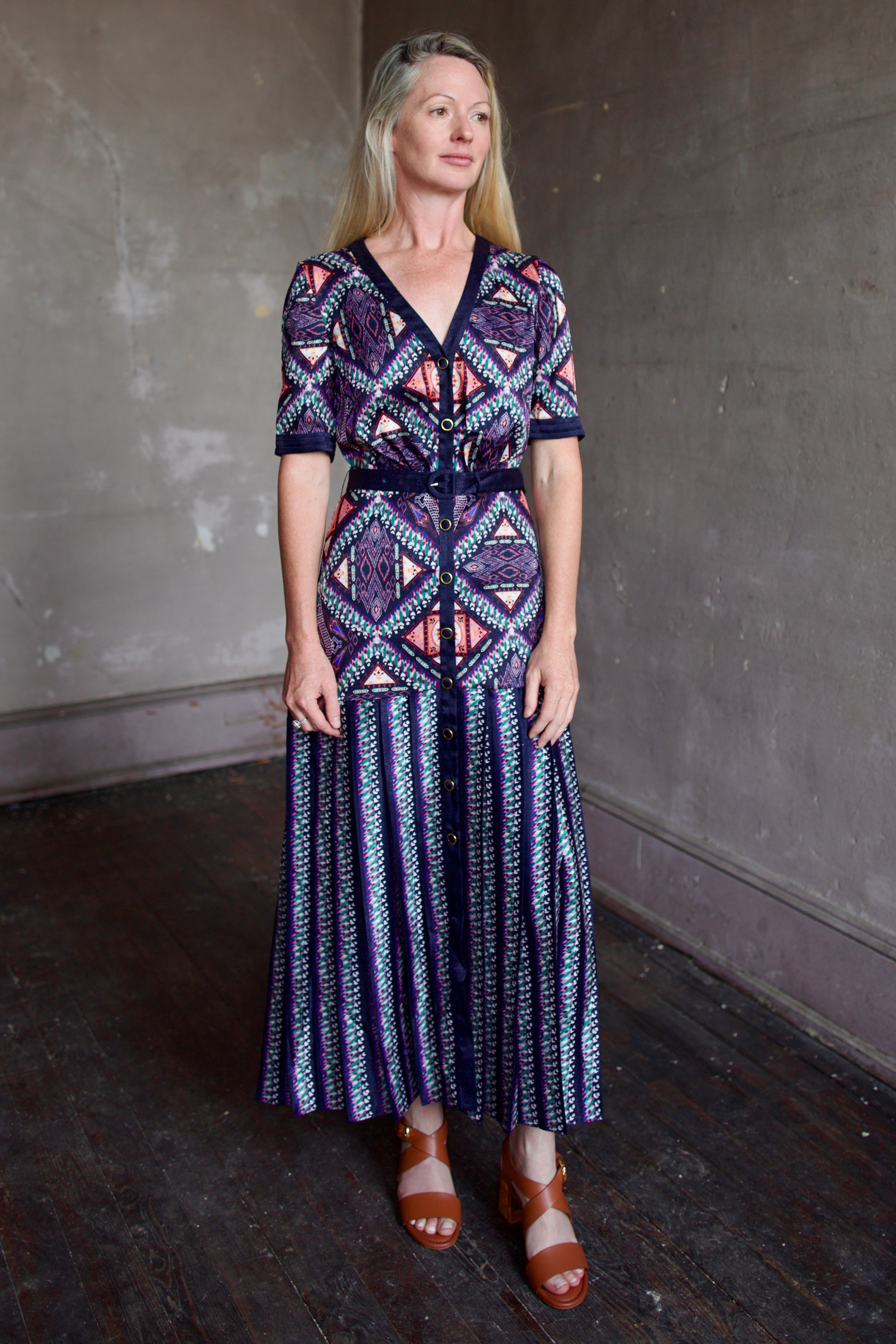 Model wearing timeless Saloni Lea drop waist shirt dress in ikat compass print and pleated 