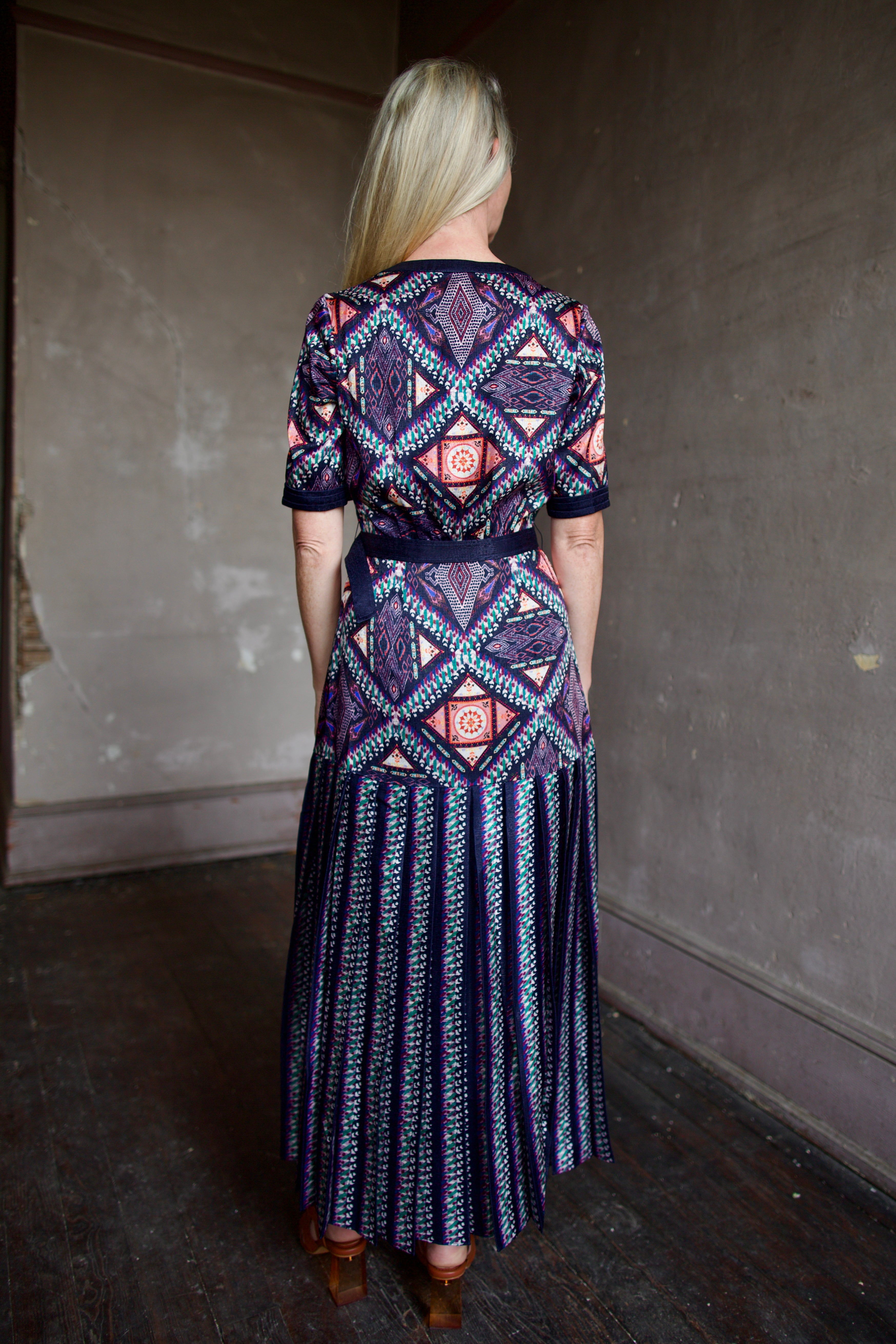 Model wearing timeless short sleeve Saloni Lea drop waist shirt dress in ikat compass print and pleated 