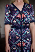 Model wearing timeless short sleeve Saloni Lea drop waist shirt dress in ikat compass print and pleated 