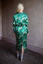 Model wearing Saloni Mya silk long sleeve green floral midi dress with embellished broach detail at waist