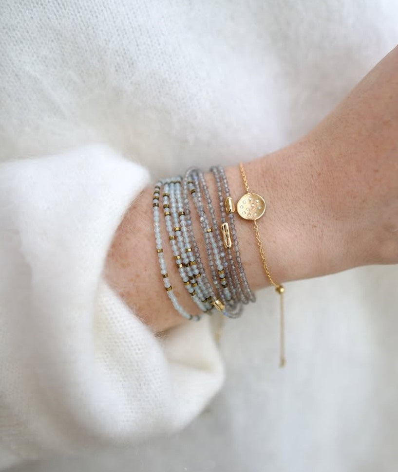 Image of woman wearing everyday luxury Anne Sportun bracelet stack with natural stones hand-hammered textures and brilliant diamond accents