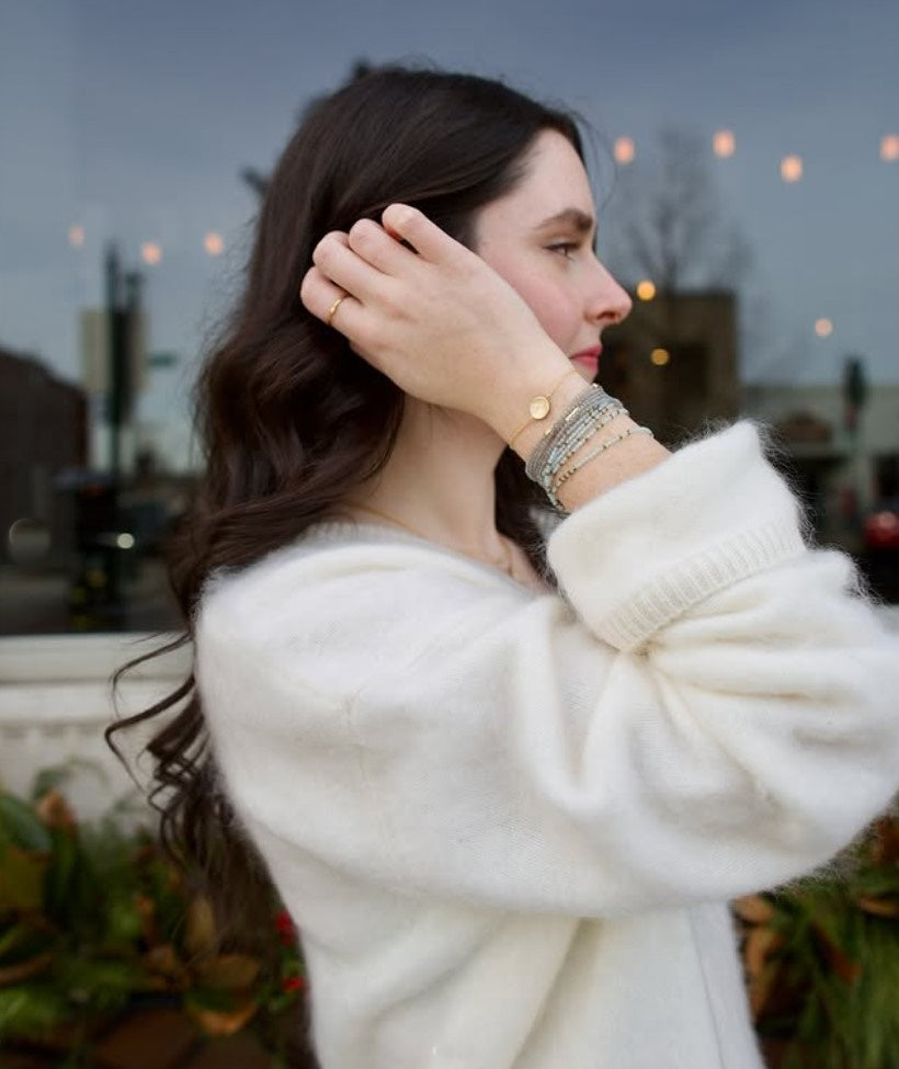 Image of woman wearing everyday luxury Anne Sportun bracelet stack with natural stones hand-hammered textures and brilliant diamond accents