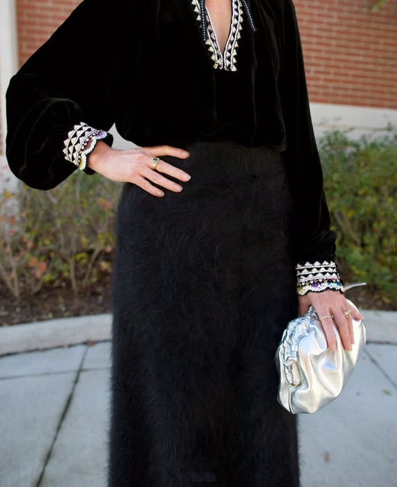 Model holding the Italian leather Mini Cloud clutch by high-end designer Mansur Gavriel in metallic silver 