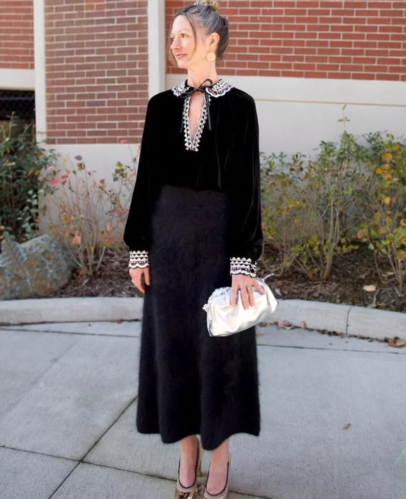 Mature model wearing the Italian leather Mini Cloud clutch by high-end designer Mansur Gavriel in metallic silver 