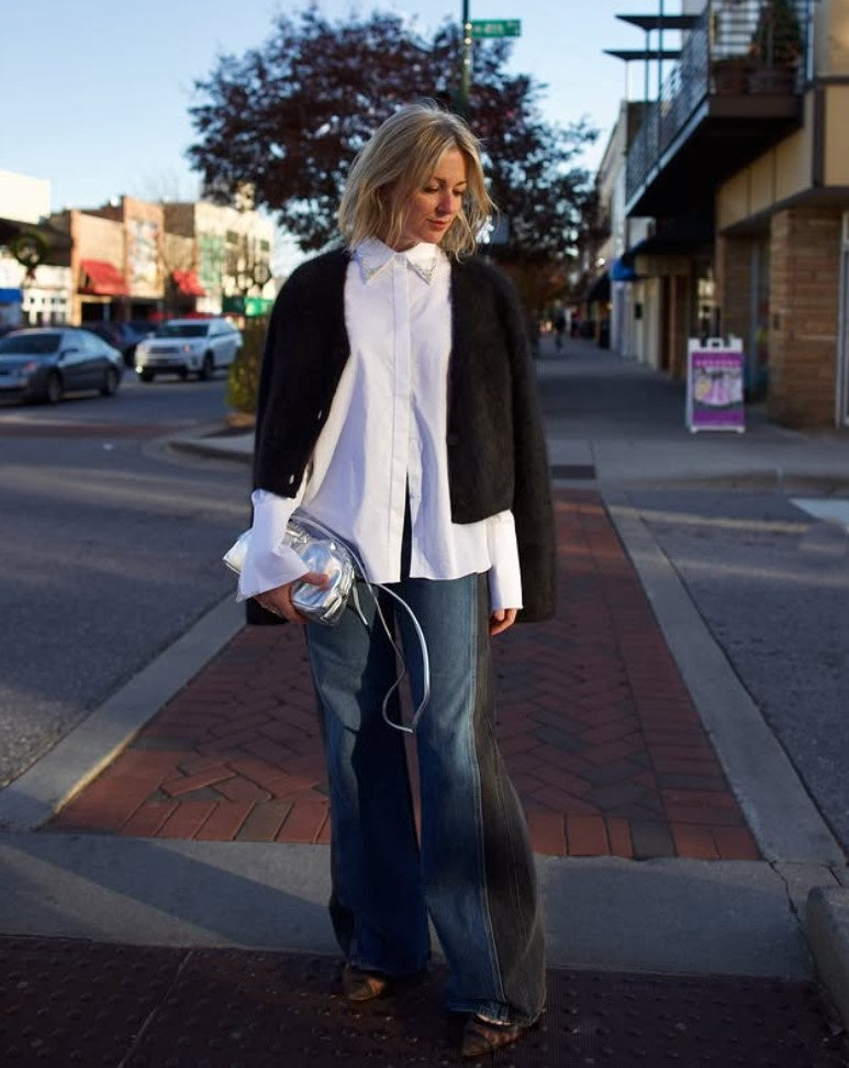 Model holding the Italian leather Mini Cloud clutch by high-end designer Mansur Gavriel in metallic silver 