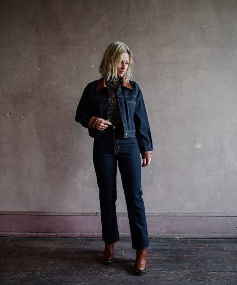Mature model wearing designer denim jean by Ulla Johnson,Louis Vuitton boots and matching denim and leather jacket