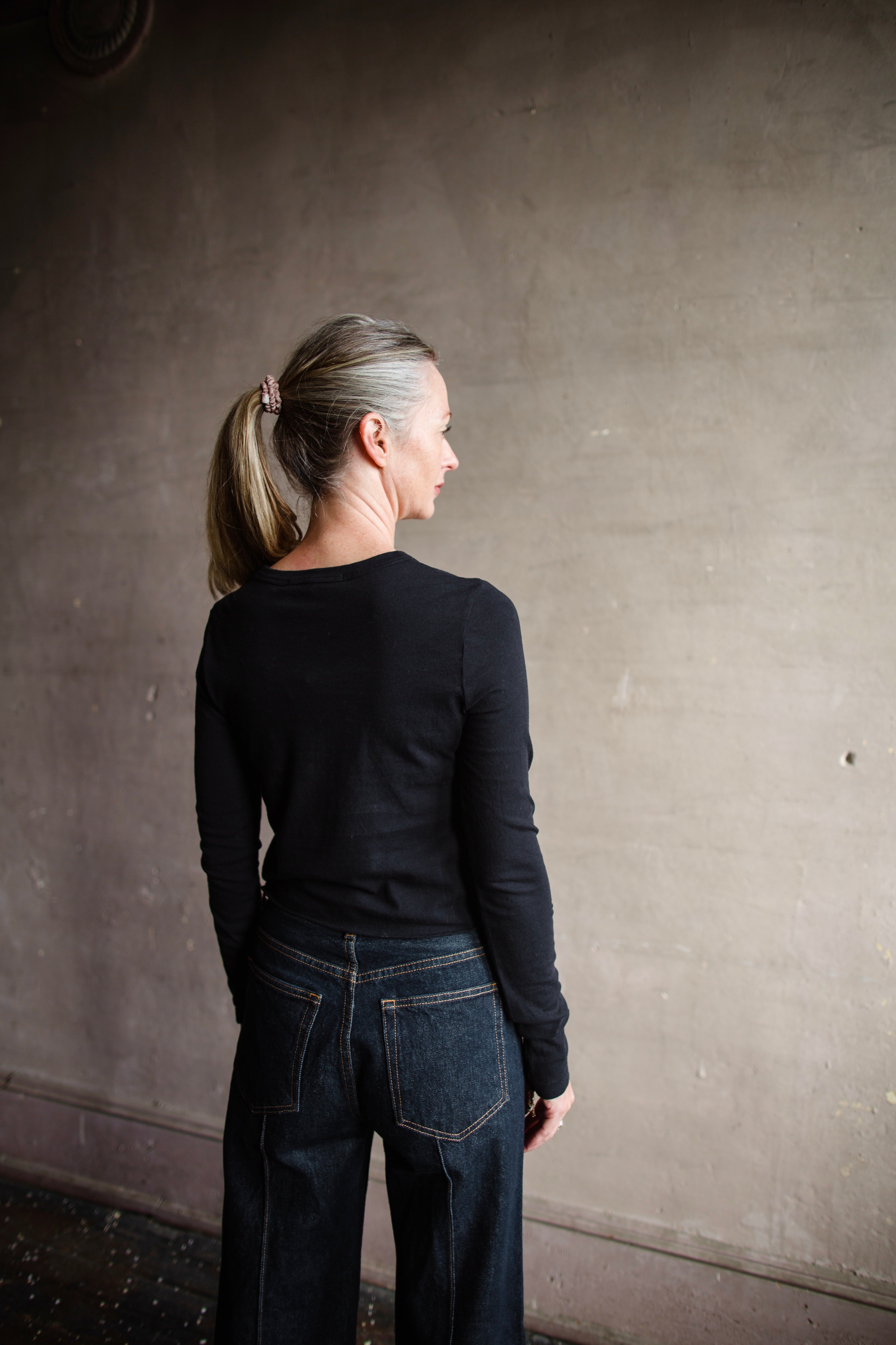 Image featuring a woman wearing the Slvrlake The Baby Long Sleeve Tee by Slvrlake baby tee with a crew neckline, long sleeves and a cropped fit fabricated in cotton.