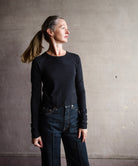 Image featuring a woman wearing the Slvrlake The Baby Long Sleeve Tee by Slvrlake baby tee with a crew neckline, long sleeves and a cropped fit fabricated in cotton.