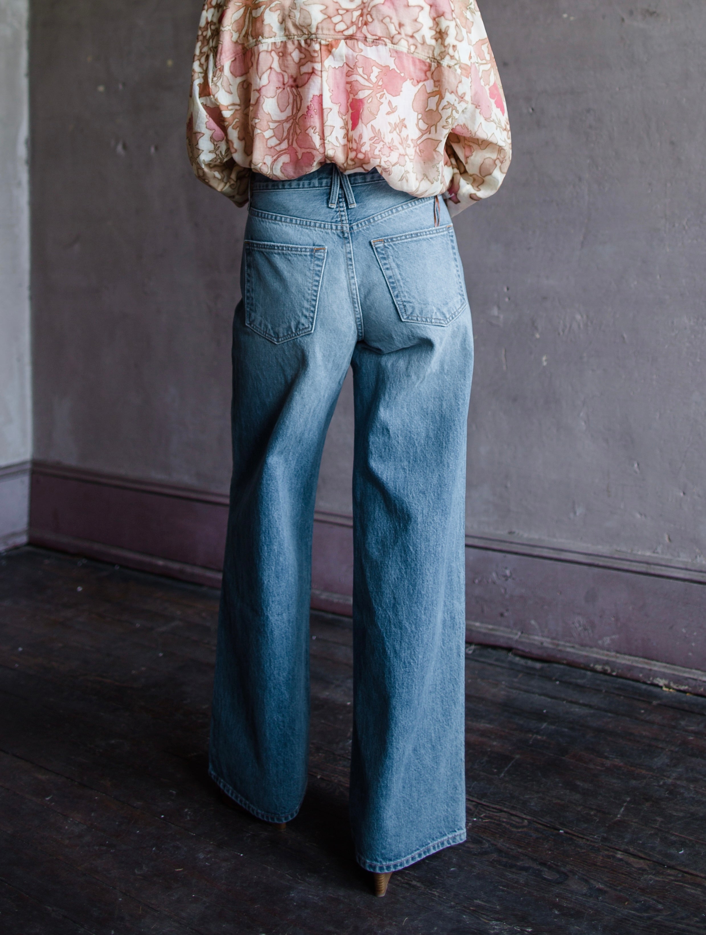 Mature woman wearing Slvrlake Selena 100% rigid cotton jeans high rise full length wide leg medium wash finished hem