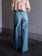 Mature woman wearing Slvrlake Selena 100% rigid cotton jeans high rise full length wide leg medium wash finished hem