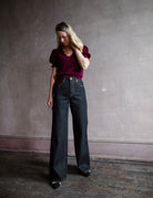 Image featuring a woman wearing the Grace jeans by Slvrlake feature a high rise and wide leg in a black finish called empty sky.