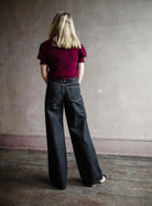 Image featuring a woman wearing the Grace jeans by Slvrlake feature a high rise and wide leg in a black finish called empty sky.