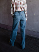 Image featuring a woman wearing the Grace jeans by Slvrlake in 100% cotton rigid denim with a high rise and full length, wide leg and separate ways wash.