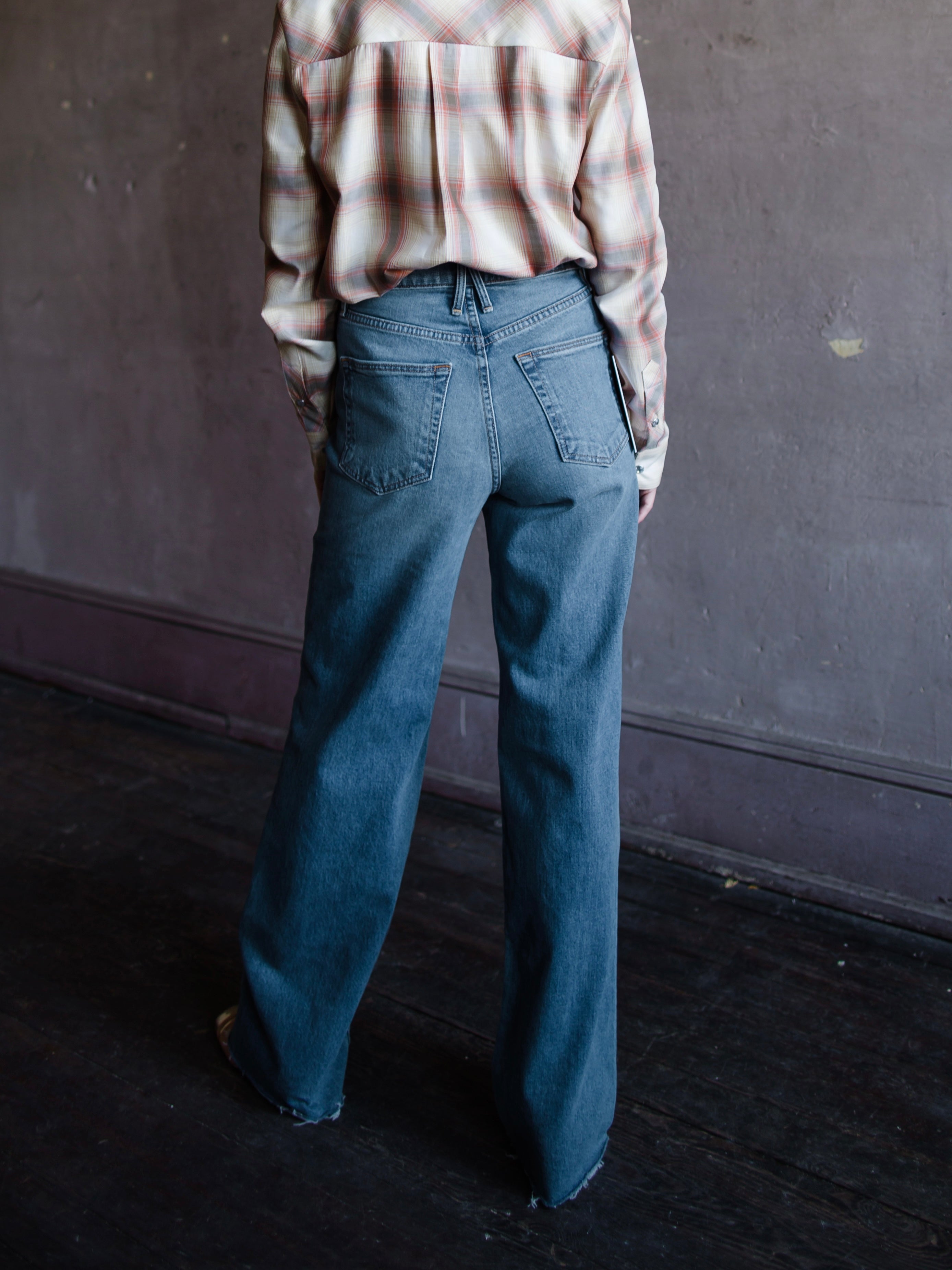 Image featuring a woman wearing the Grace jeans by Slvrlake in 100% cotton rigid denim with a high rise and full length, wide leg and separate ways wash.