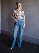 Mature woman wearing Slvrlake Grace denim jeans in 100% cotton rigid denim high rise full length wide leg medium wash