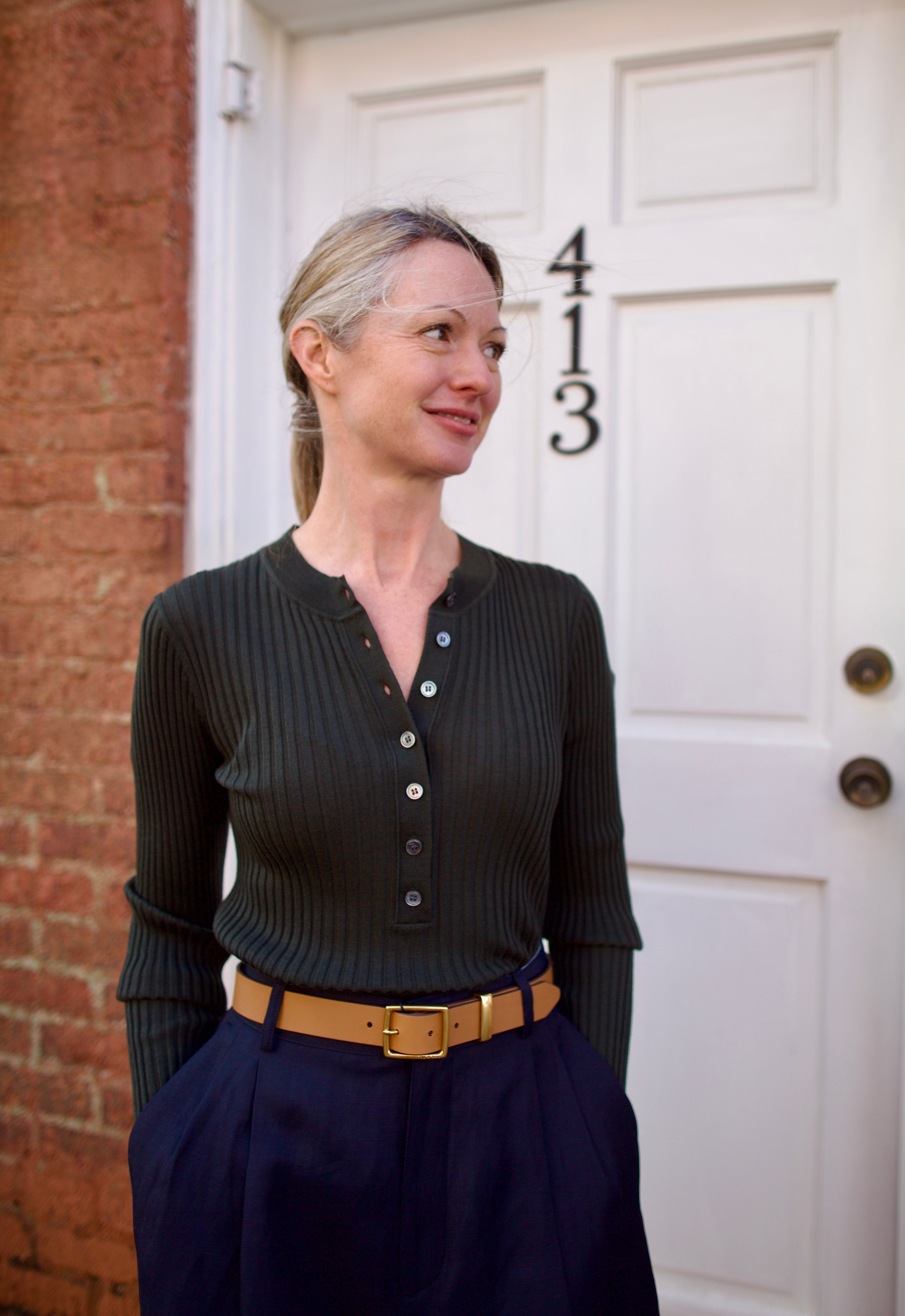 Image of a woman wearing the Soeur Buffalo Ribbed Henley, Rag and Bone Belt and Apiece Apart Trousers