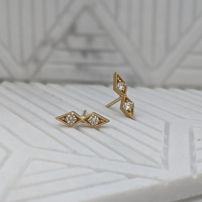 Image featuring North Carolina artist Stephanie Ellis’s diamond double star stud earrings in recycled 14-karat yellow gold with 4-2mm SI1-G white round brilliant diamonds. 