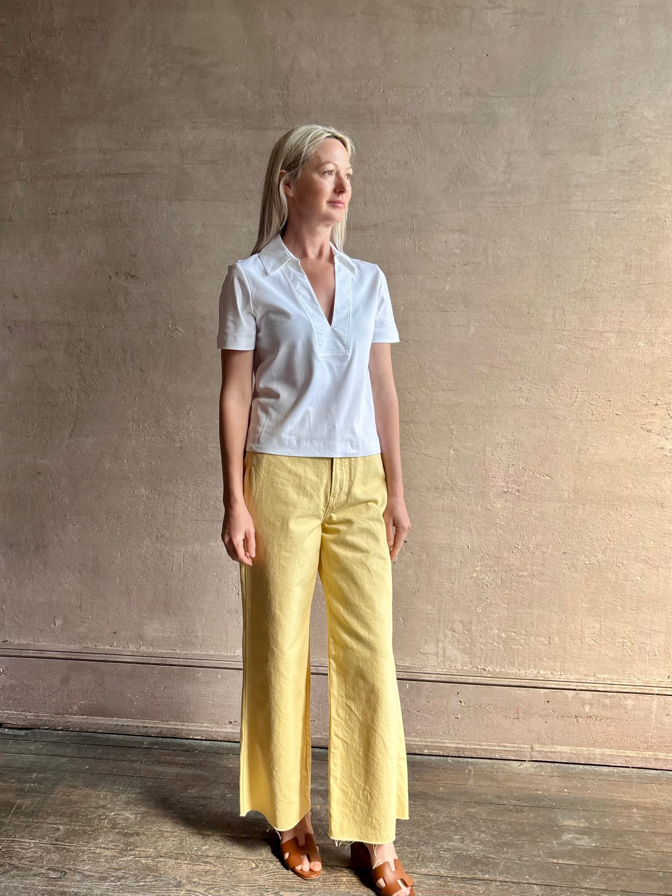 Mature woman wearing timeless white Melanie Top from Tanya Taylor crafted from 100% organic cotton jersey with v-neck and short sleeves in effortless relaxed fit for an elevated waredrobe staple