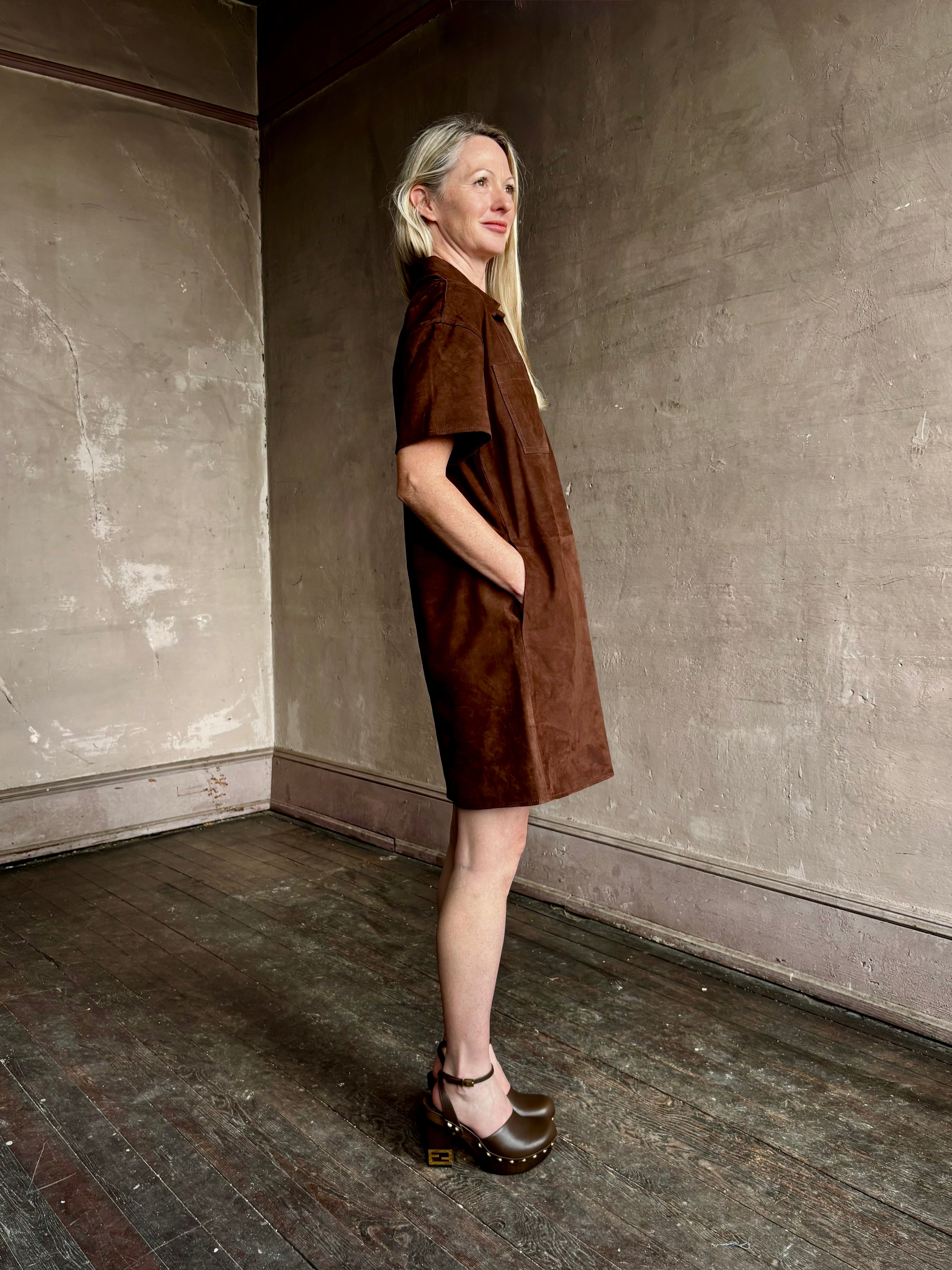 Image of mature woman wearing designer Tanya Taylor sleek chocolate leather shift dress with V-neck and structured collar