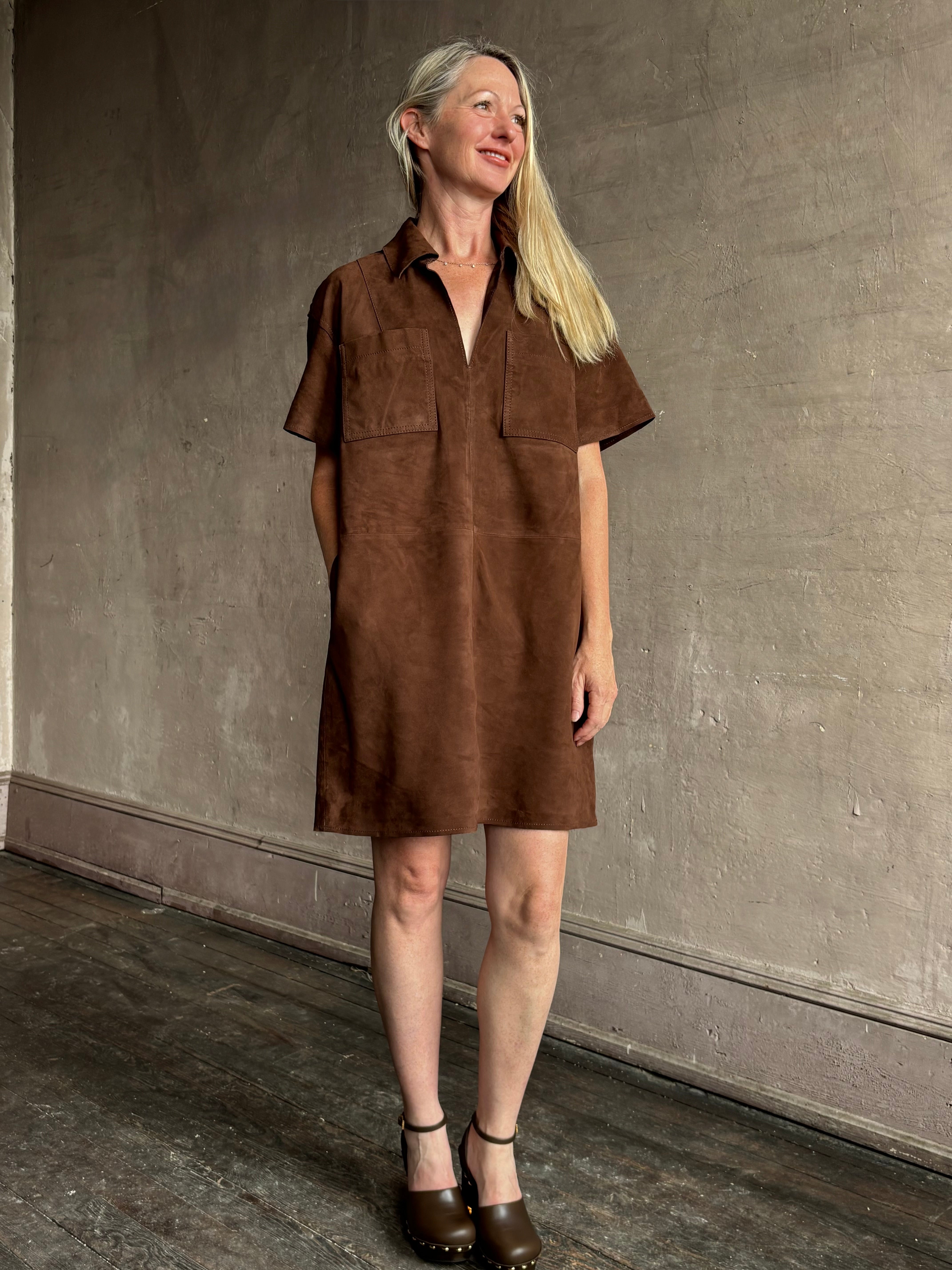 Image of mature woman wearing designer Tanya Taylor chocolate leather shift dress with above-knee hemline and hidden pockets