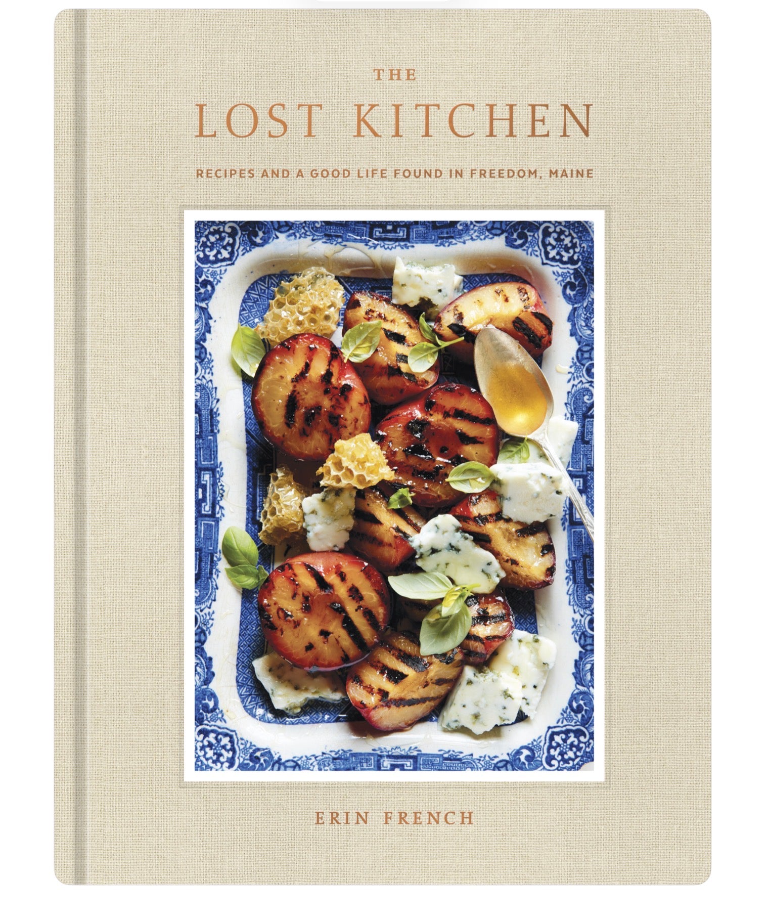 The Lost Kitchen cookbook cover by Erin French, featuring grilled peaches and cheese dish on a blue-and-white plate