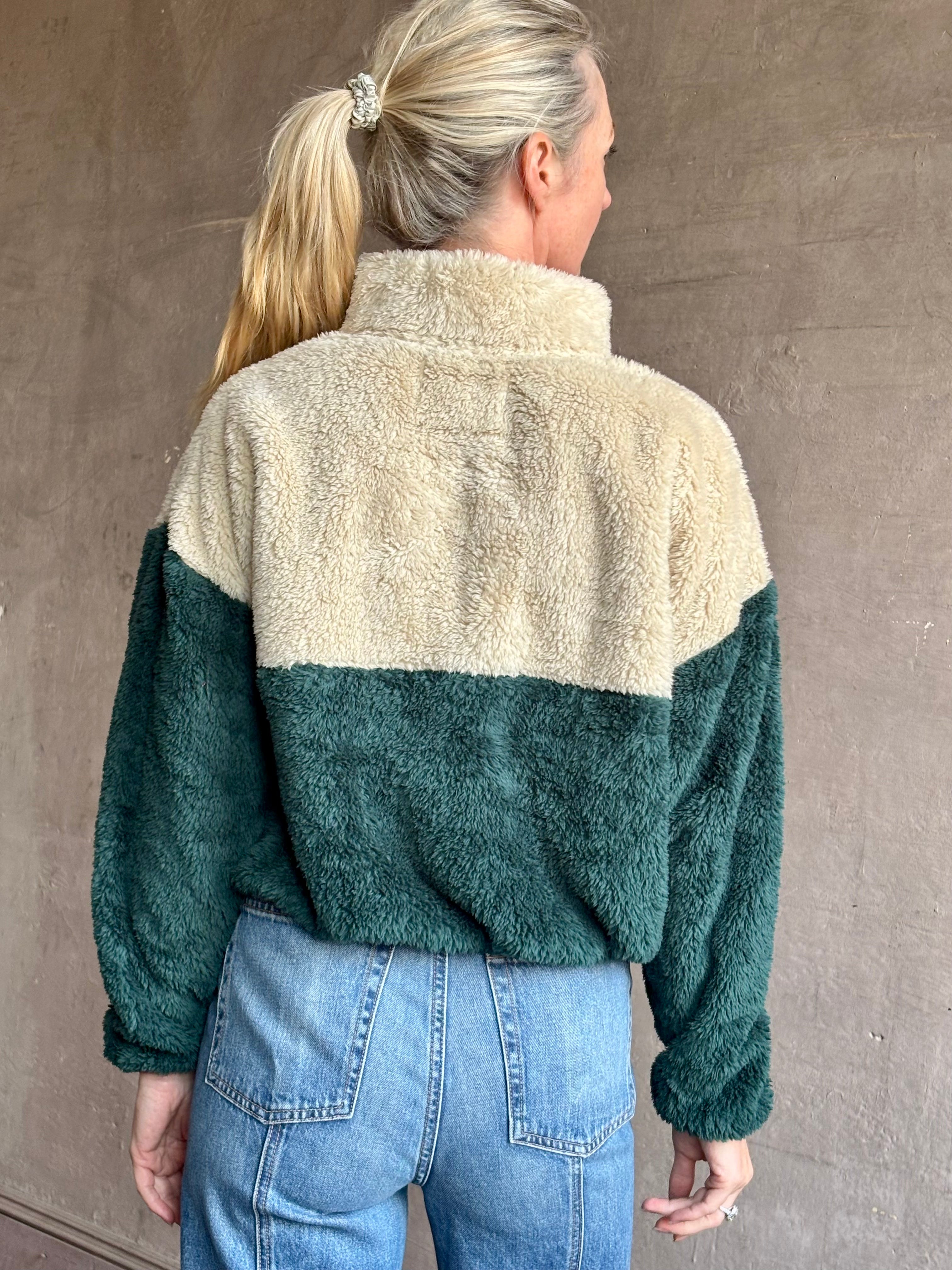 Image of mature woman wearing Trovata Casey premium fleece quarter zip Pullover in Ponderosa green orange and cream colorway