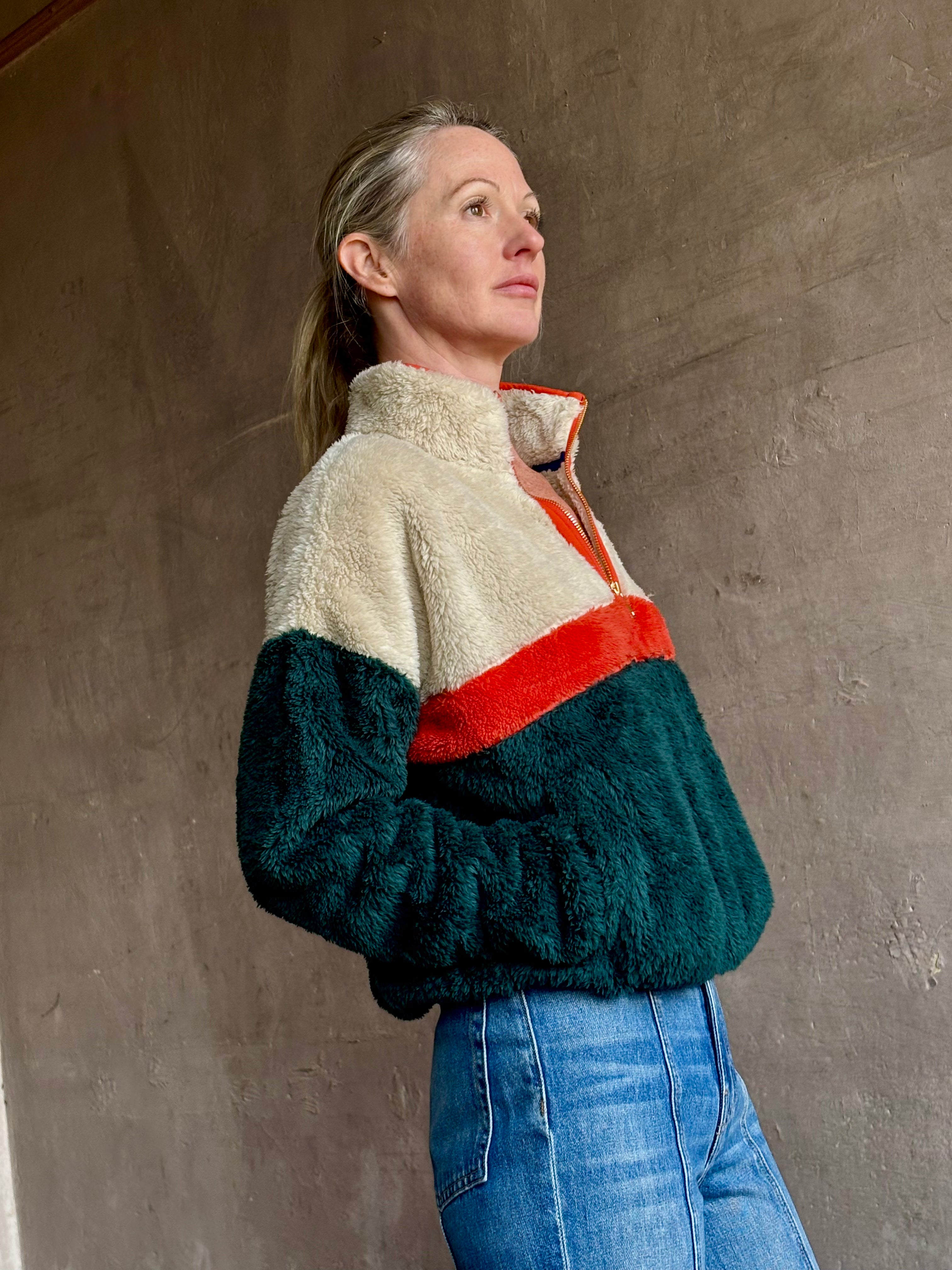 Image of mature woman wearing Trovata Casey premium fleece quarter zip Pullover in Ponderosa green orange and cream colorway