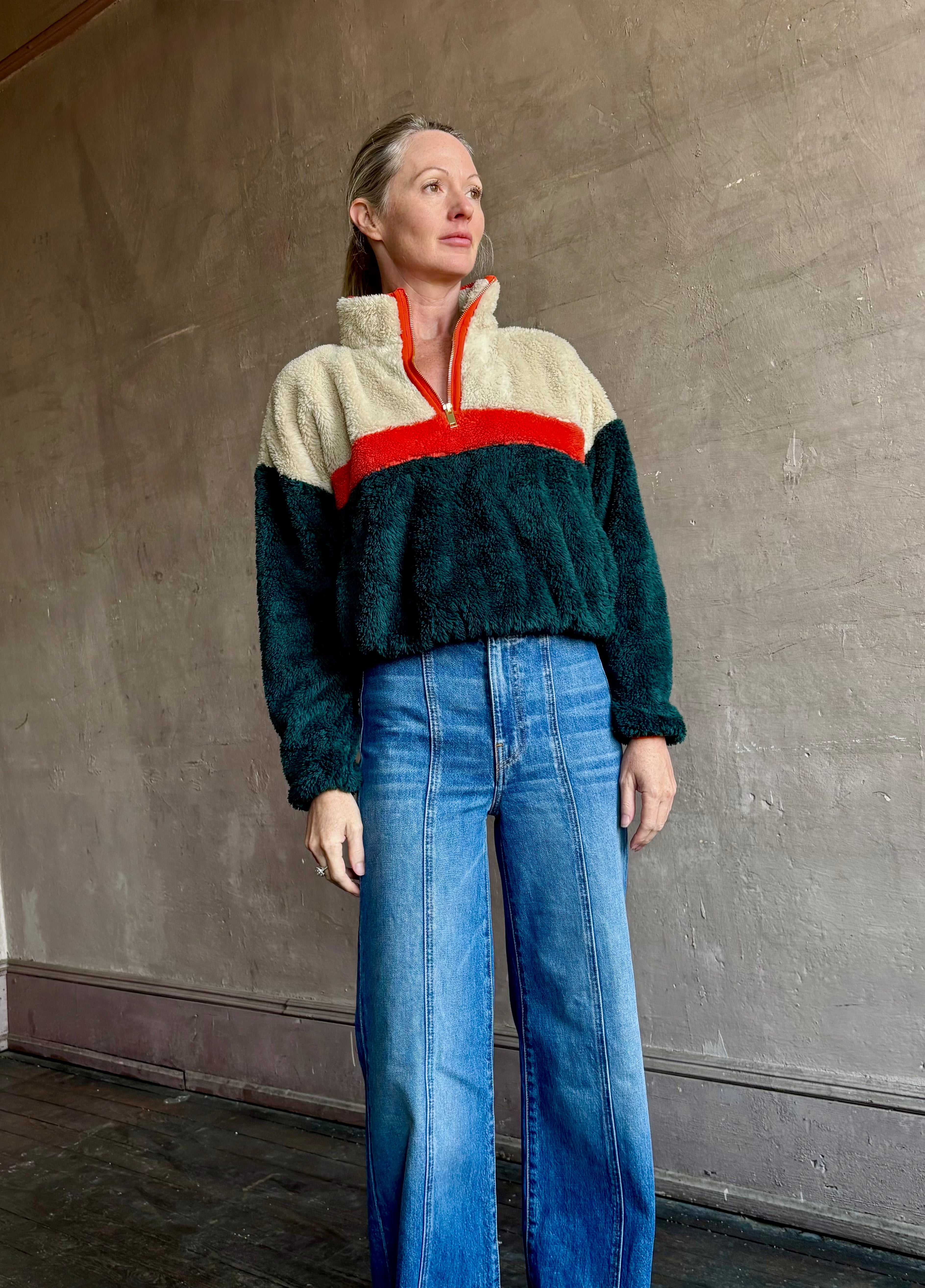 Image of mature woman wearing Trovata Casey premium fleece quarter zip Pullover in Ponderosa green orange and cream colorway