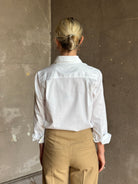 woman wearing white Trovata Justine blouse collared V-neck button-front closure cuffed long sleeves classic silhouette 