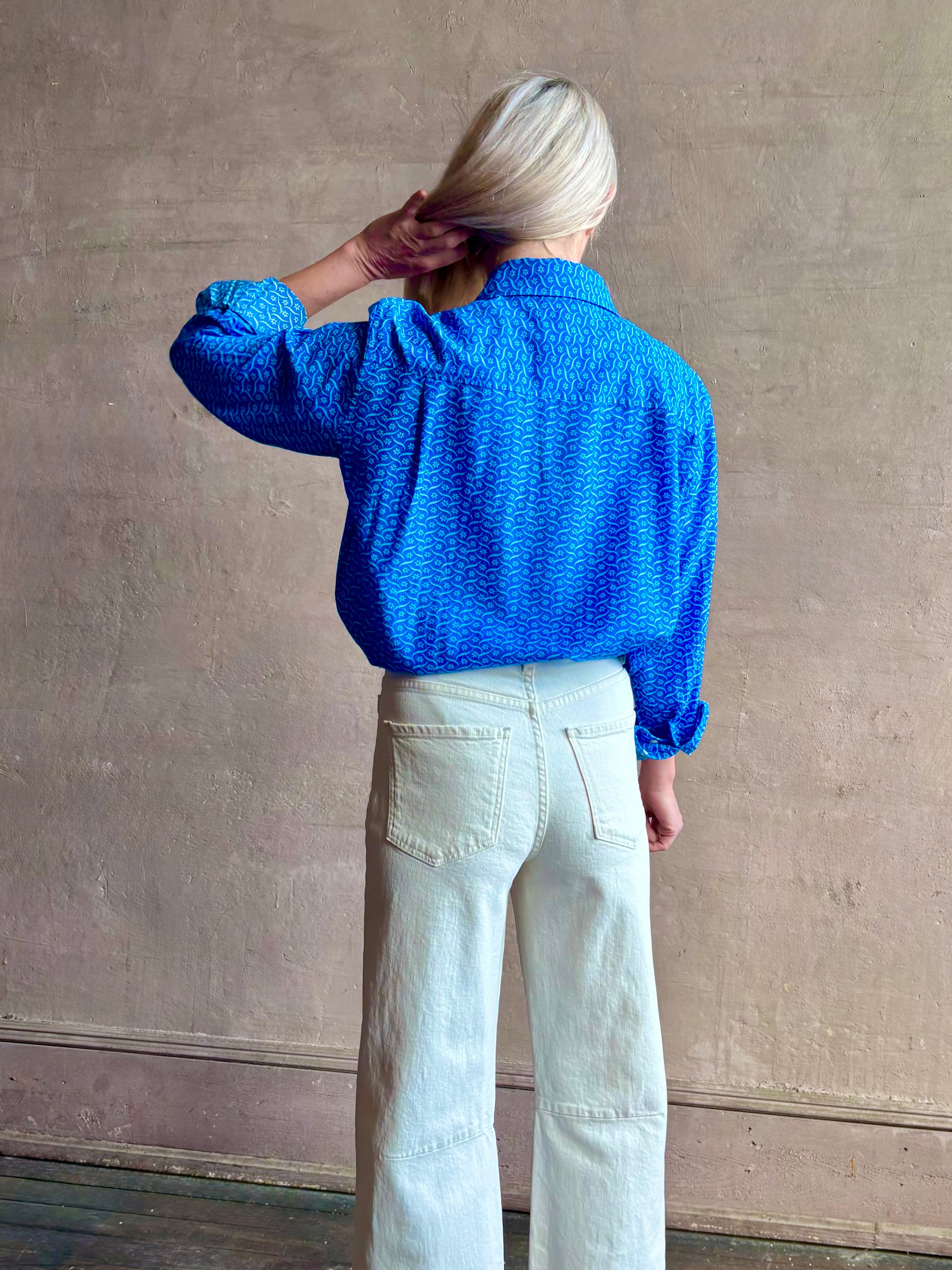 Image of woman wearing the ultimate casual elegance TROVATA Emilia cotton blend button down long sleeve Shirt in Cerulean blue contemporary floral print 