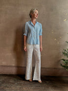 Mature woman wearing Jess Blouse from Trovata rendered in the light blur and crafted from cotton poplin with peter pan collar, half sleeves, intricate pitucking and button front