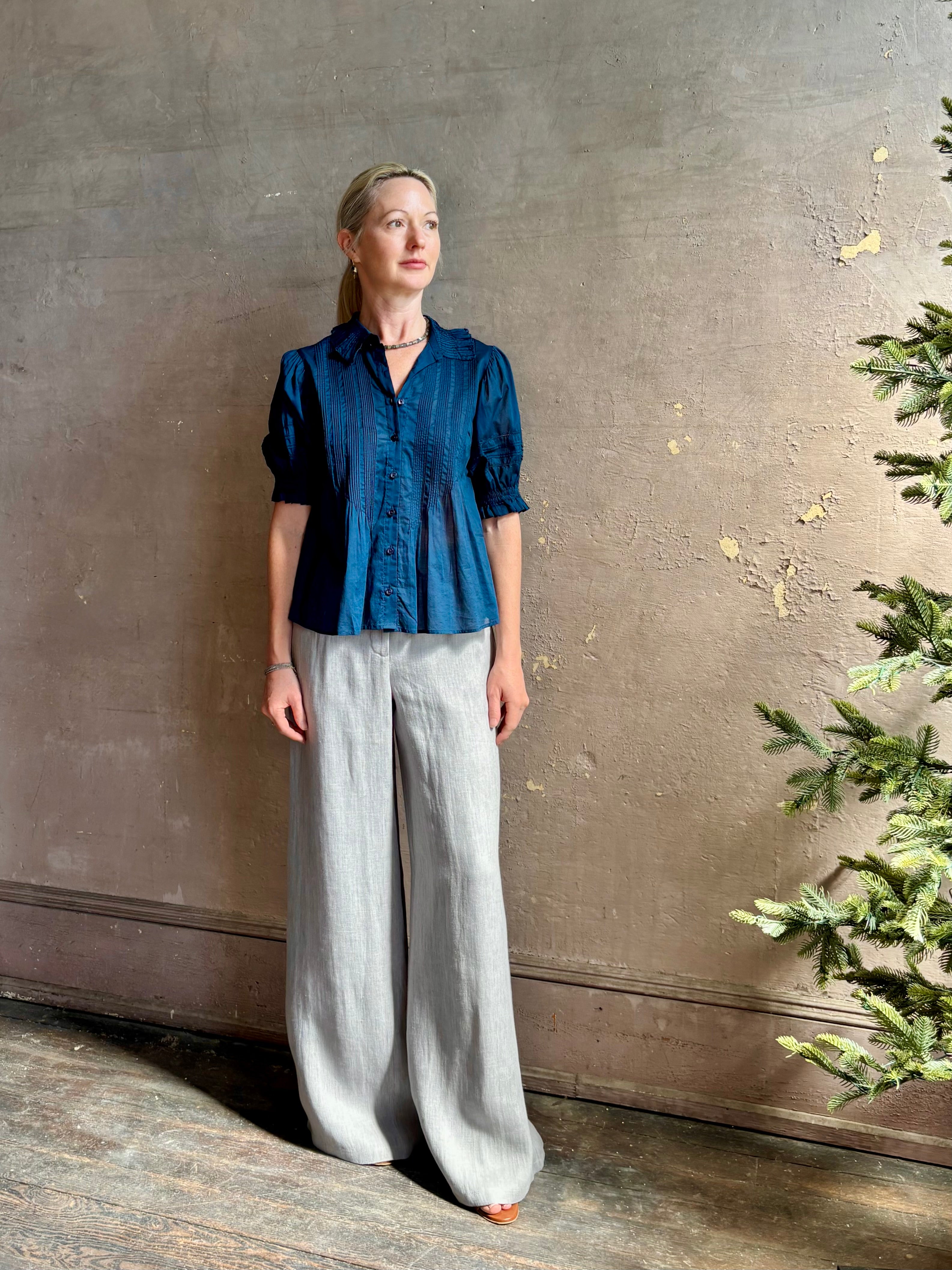 Mature woman wearing Trovata Jess Blouse with short sleeves, peter pan collar, v-neck button front and  intricate pintucking