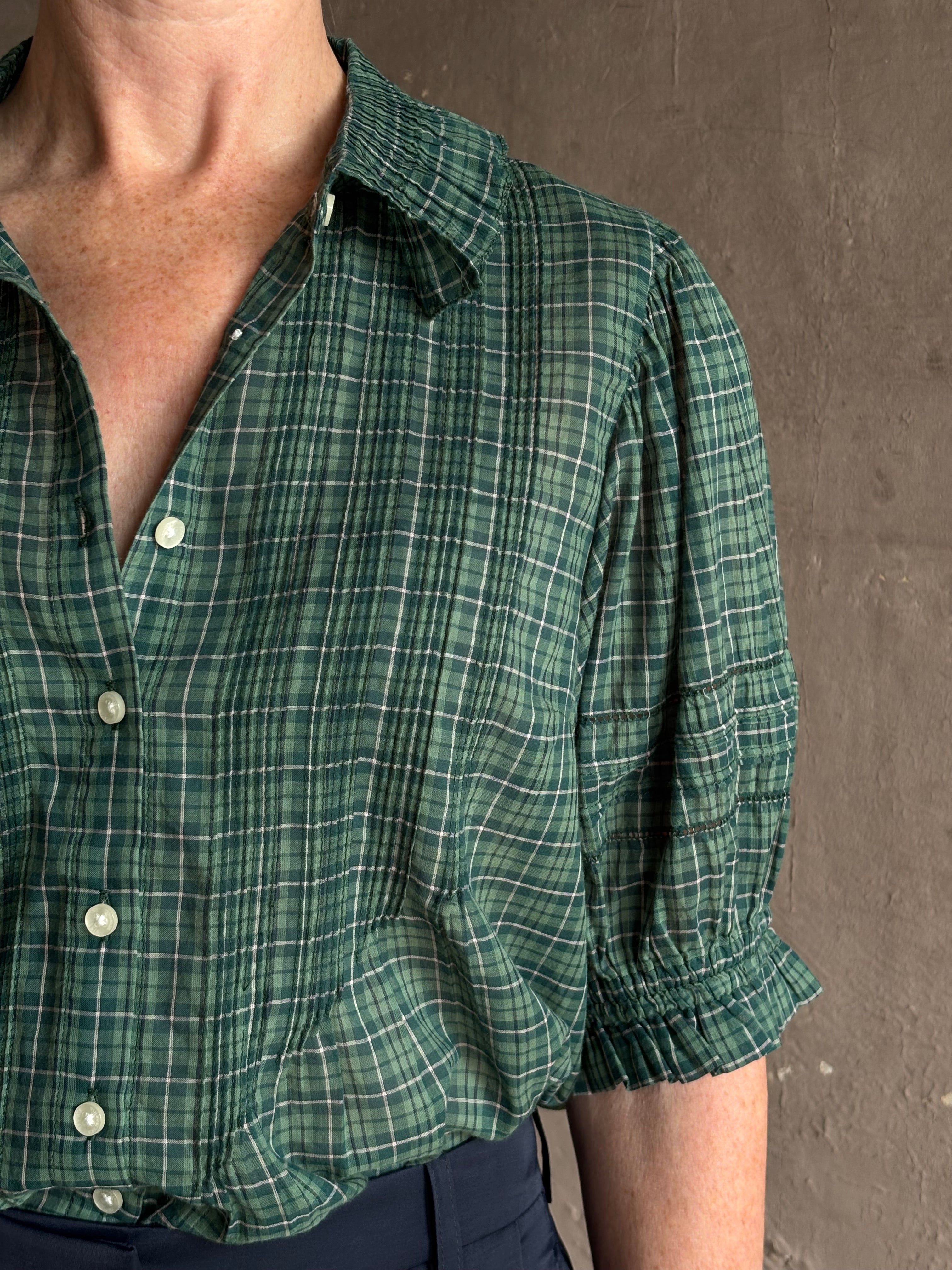 Mature woman wearing Trovata Jess green plaid short sleeve cotton poplin blouse with pintucking and peter pan collar