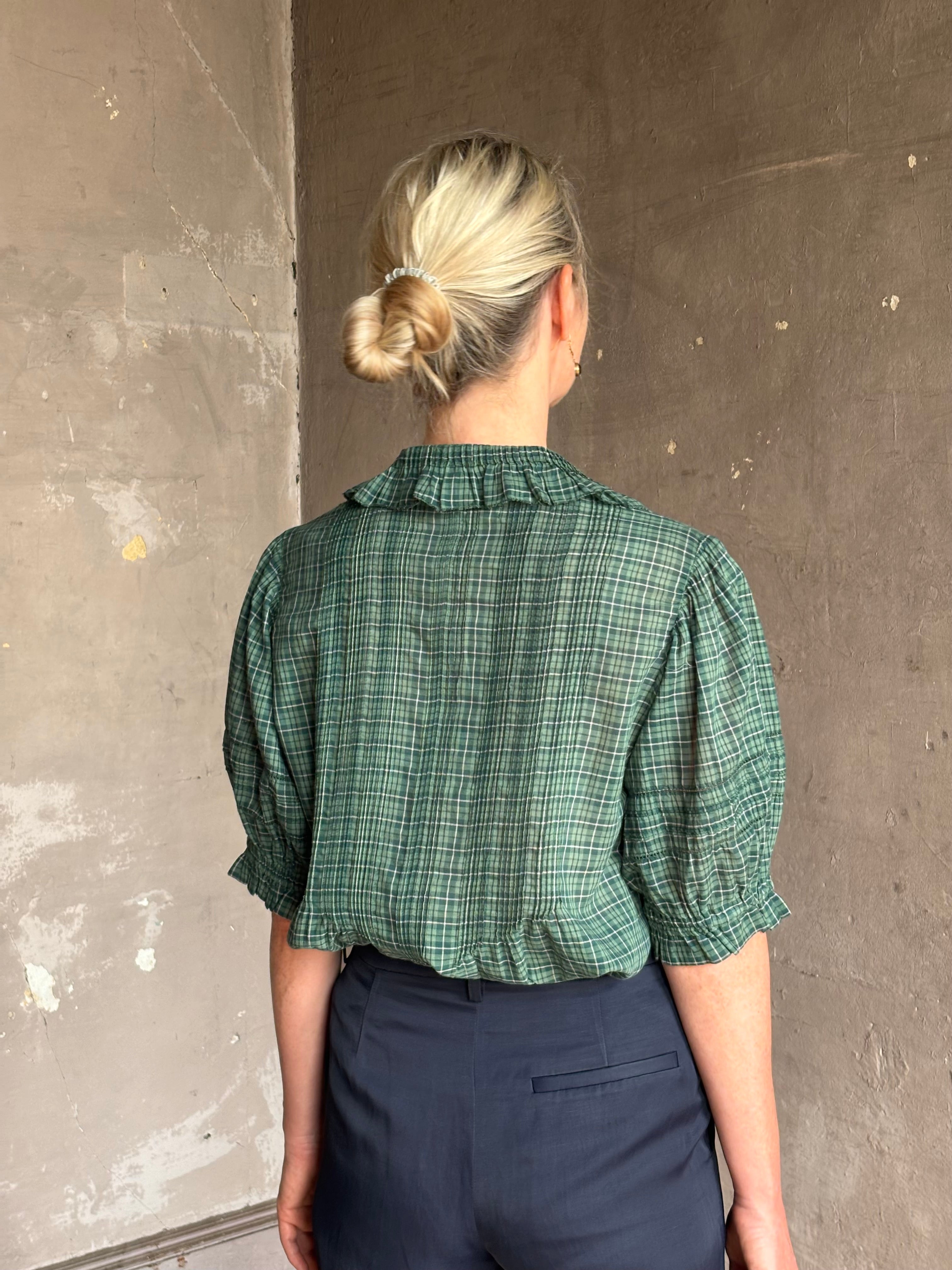 Mature woman wearing Trovata Jess green plaid short sleeve cotton poplin blouse with pintucking and peter pan collar